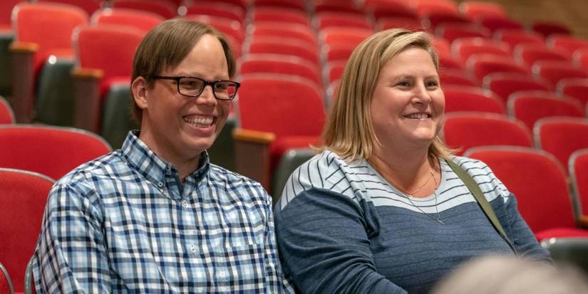 Sam (Bridget Everett) and Joel (Jeff Hiller) laughing during a recital in Somebody Somewhere season 2 episode 2.