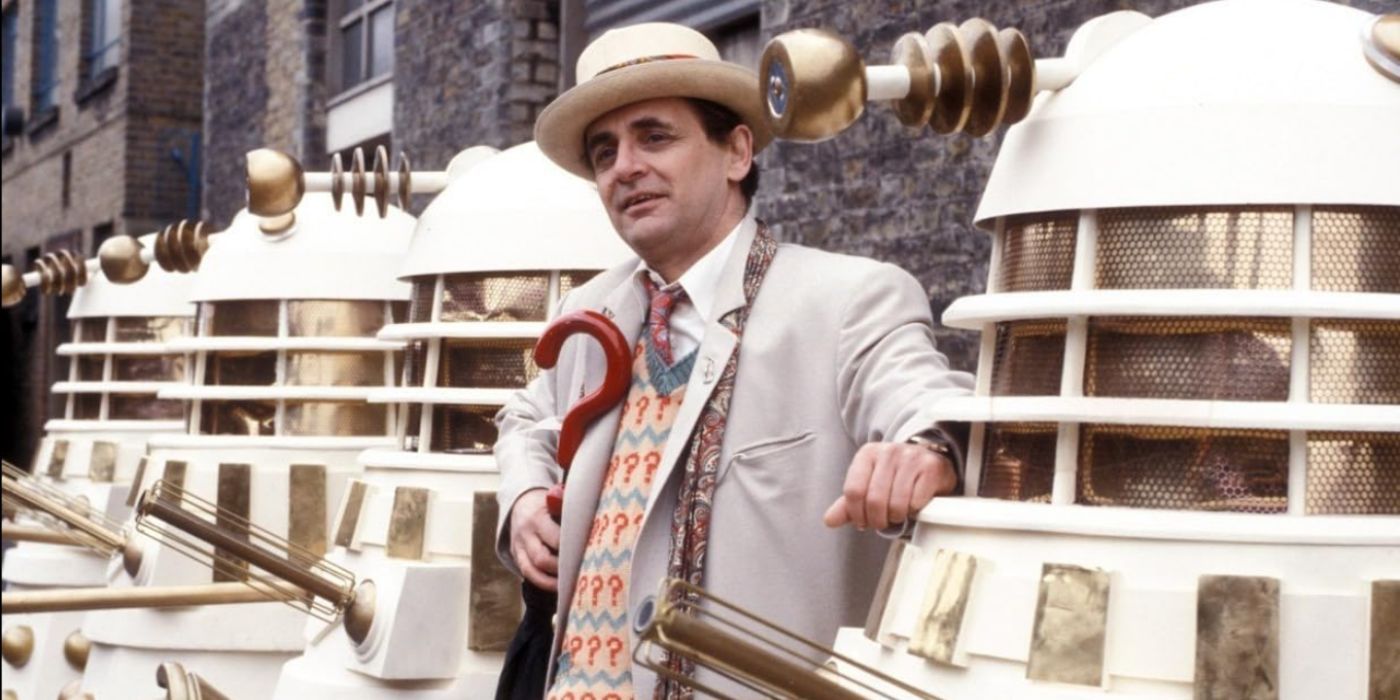 Sylvester McCoy as the Seventh Doctor, posing with several Daleks