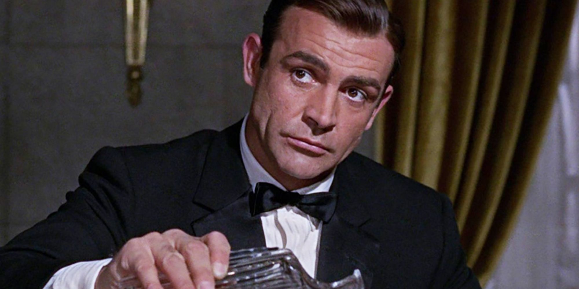 Sean Connery as James Bond pouring himself a drink