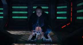 Alan Tudyk as Harry Vanderspeigle in Resident Alien smiling as he lowers Bridget to the ground