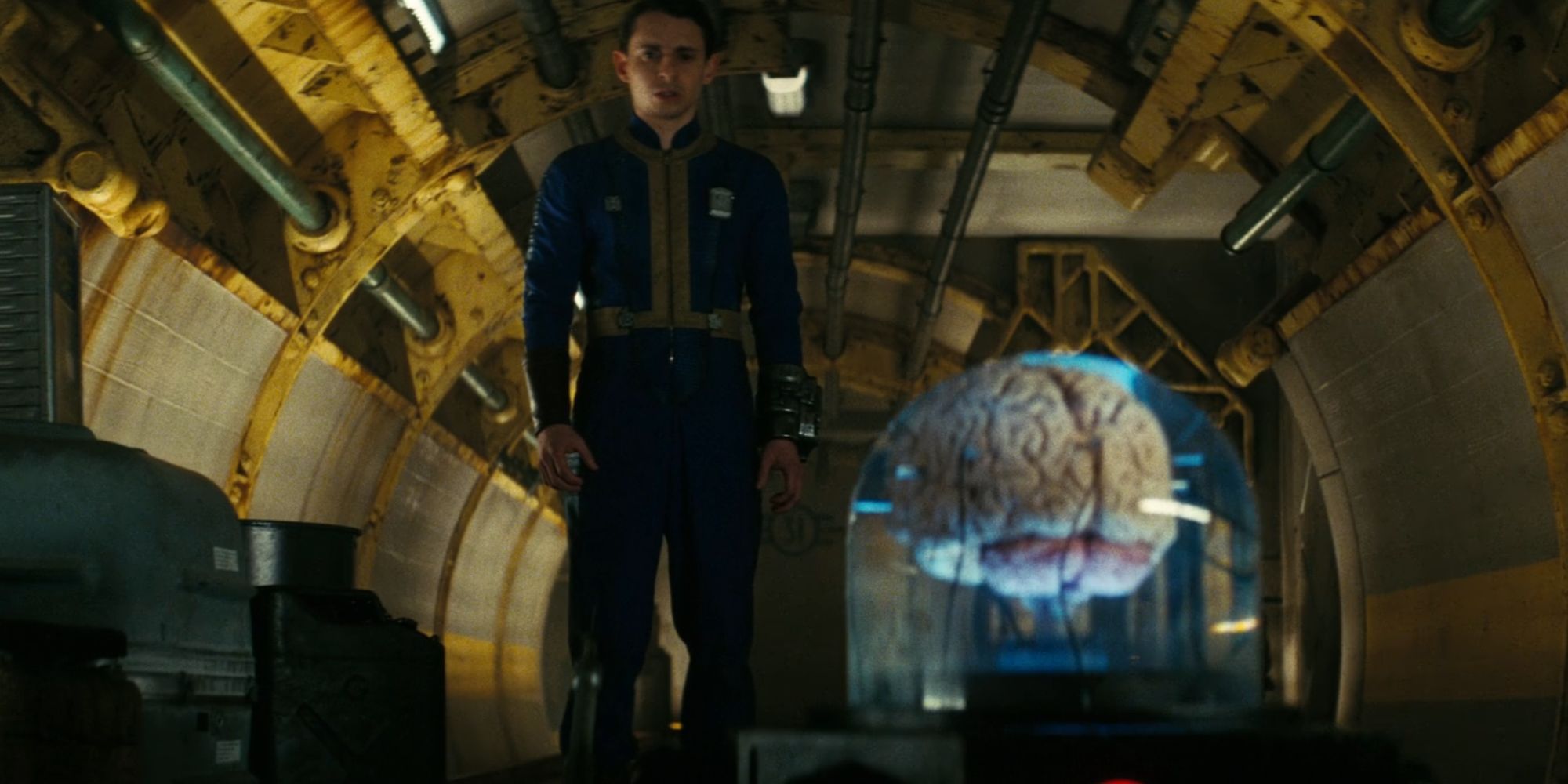 Moises Arias as Norm MacLean looking confused as he inspects the Robobrain in Fallout