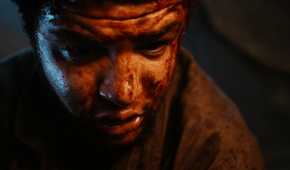 a close up of a bloodied Perrin looking down at his dying wife in The Wheel of Time season 1 episode 1