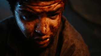 a close up of a bloodied Perrin looking down at his dying wife in The Wheel of Time season 1 episode 1