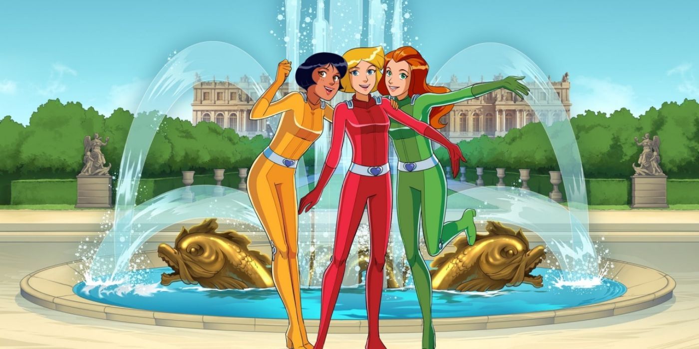 Alex, Sam, and Cloversmiling in front of a large fountain in Totally Spies!