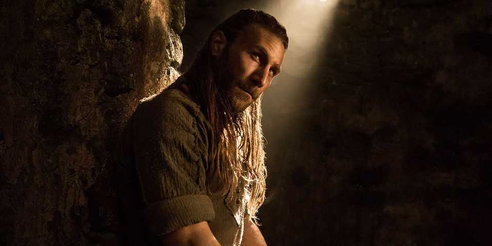 Charles Vane looks to the side while sitting in a jail in Black Sails