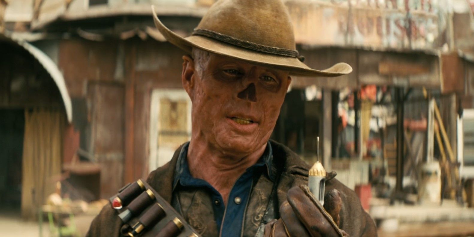 The Ghoul (Walton Goggins) holds a syringe in his hand while speaking to Lucy MacLean in Fallout