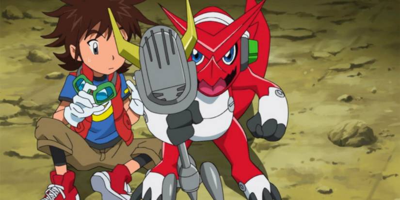 Digimon Fusion's Mikey sitting on the ground with Shoutmon holding up his microphone.