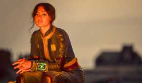 Ella Purnell as Lucy sits by a fire in the Wasteland in Fallout