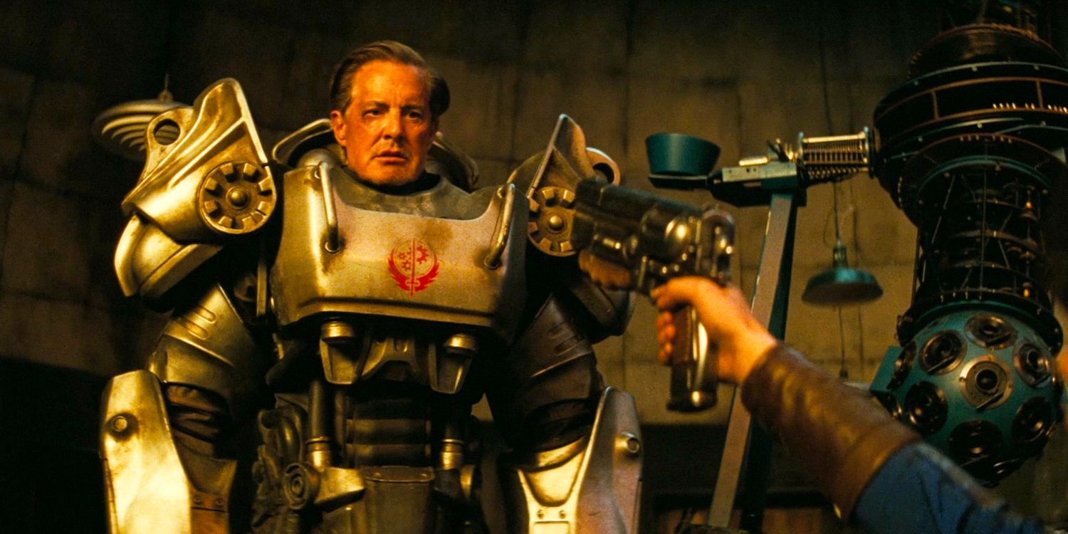 Hank MacLean wearing a power armor suit while being aimed at by a gun held by his daughter Lucy MacLean in Fallout season 1