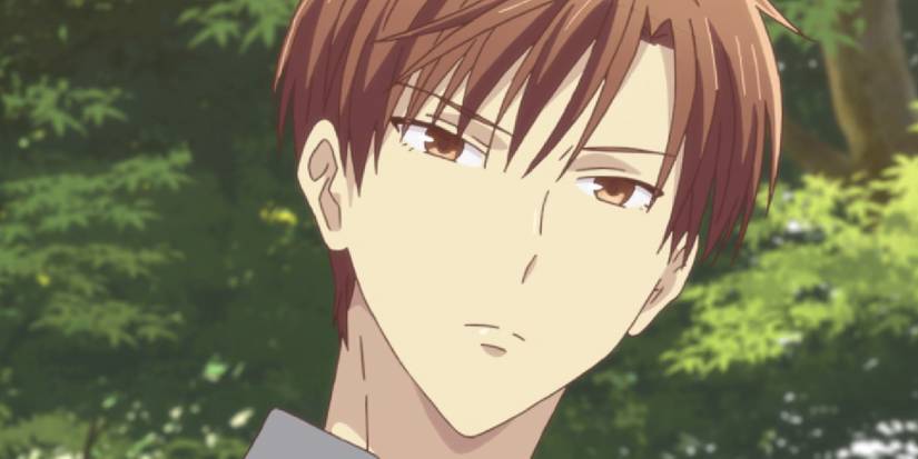 Fruits Basket's Kureno looks stern with some trees and leaves behind him.