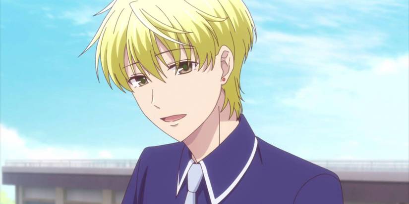 Fruits Basket's Momiji in a school uniform talking with a building behind him.