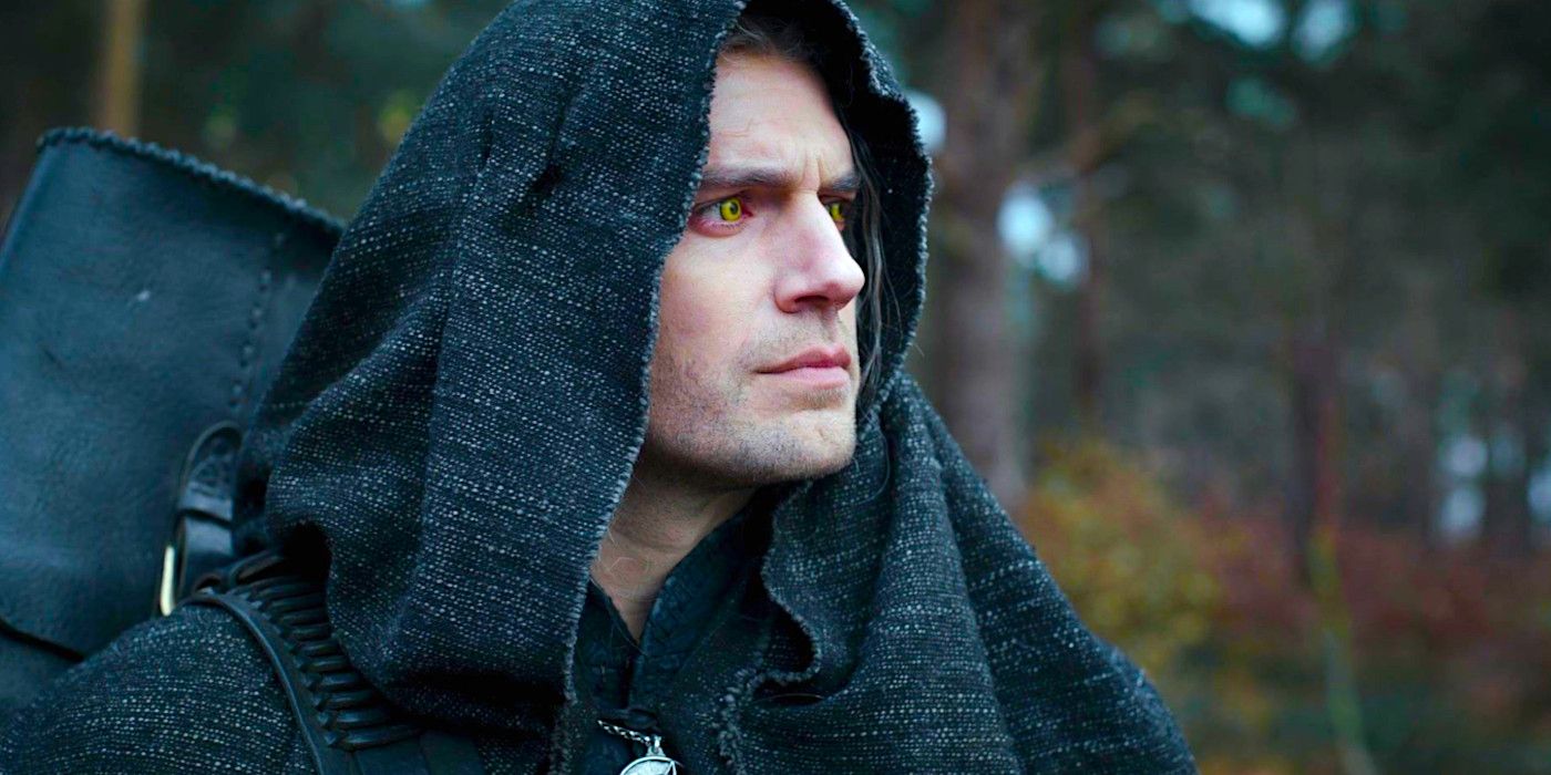 A hooded Henry Cavill gazes forward with a concerned expression in a scene from The Witcher.