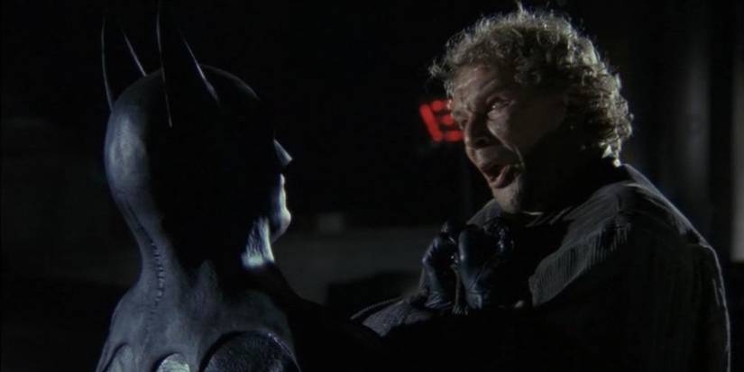 michael keaton as batman holding up a scared mugger and telling he's batman in batman 1989