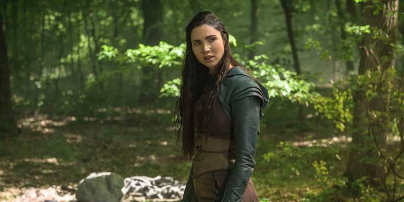 Jessica Green looks over her shoulder in the woods in The Outpost
