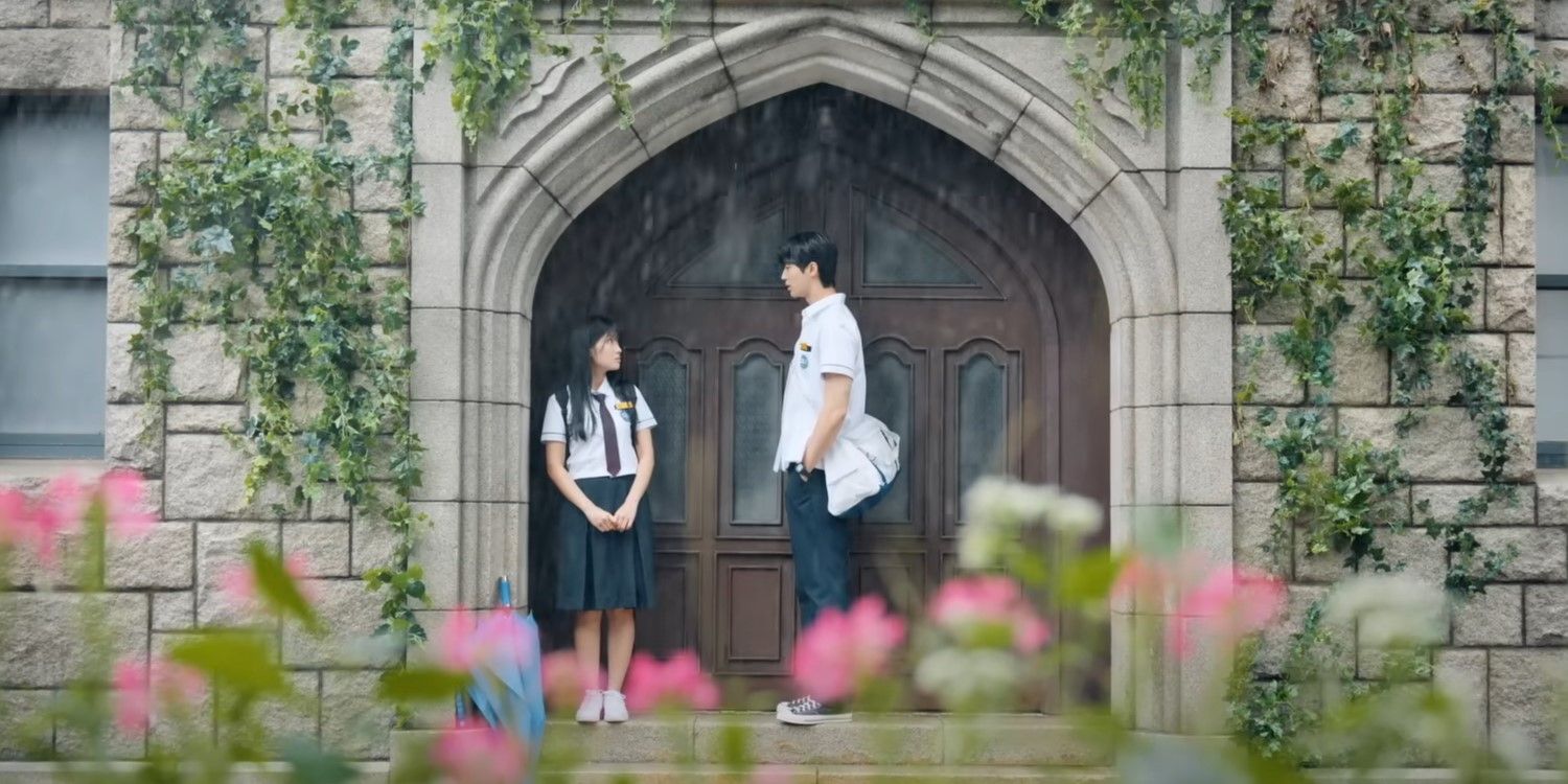 Lovely Runner's Im Sol and Ryu Sun-jae stand in an archway away from the rain.