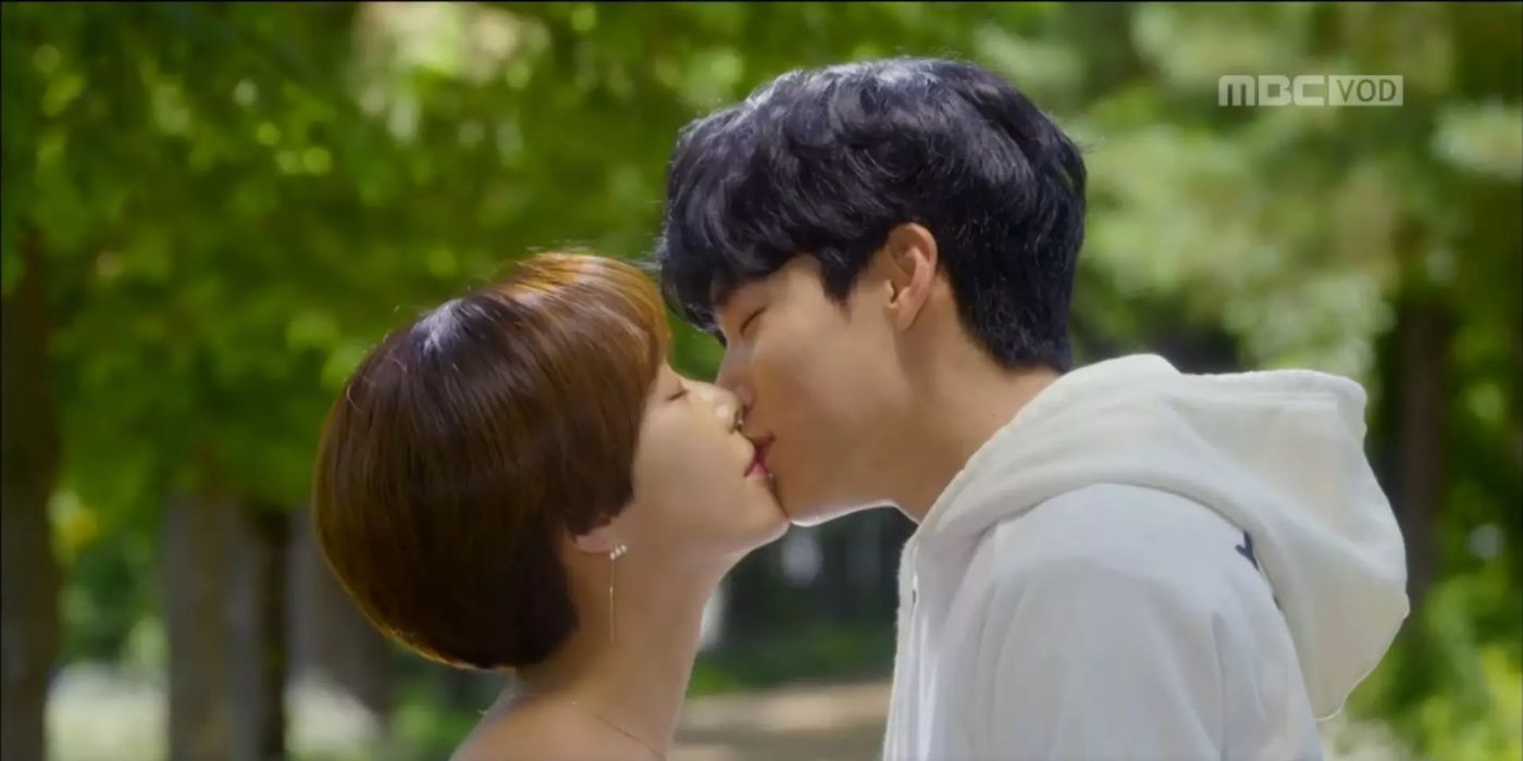 A man kisses a woman in the park in Lucky Romance