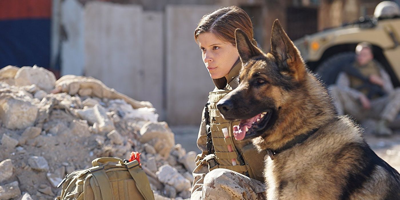 Megan (Kate Mara) and Rex crouch and look ahead in Megan Leavey