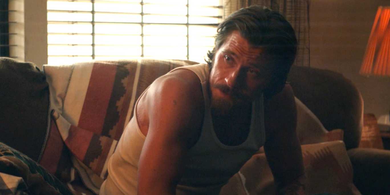 Mitch Keller (Garrett Hedlund) leans on his knees in a white tank top in Tulsa King