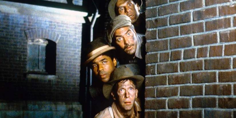 The three escapees hide behind a wall with Tommy in O Brother Where Art Thou