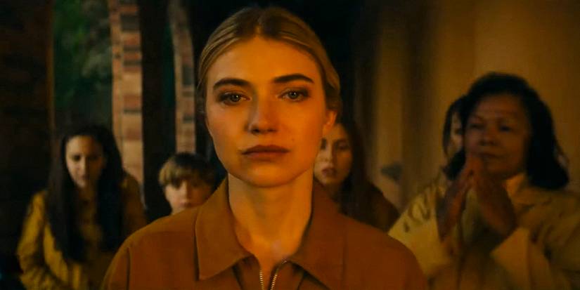 Autumn Rivers expressionless, followed by several people, all dressed in yellow in Outer Range season 2