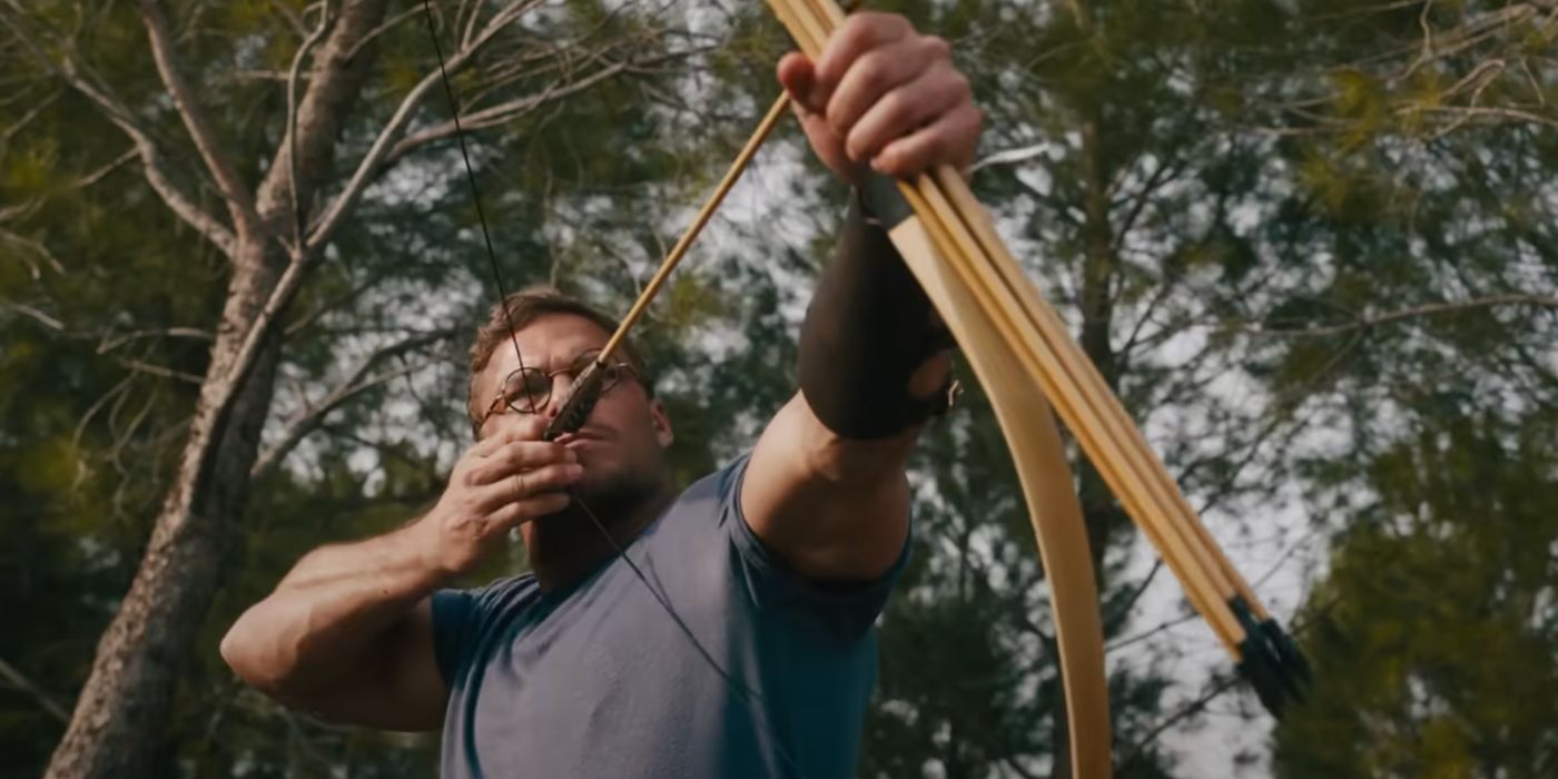 Alan Ritchson as Anders Lassen aiming his bow and arrow in The Ministry of Ungentlemanly Warfare