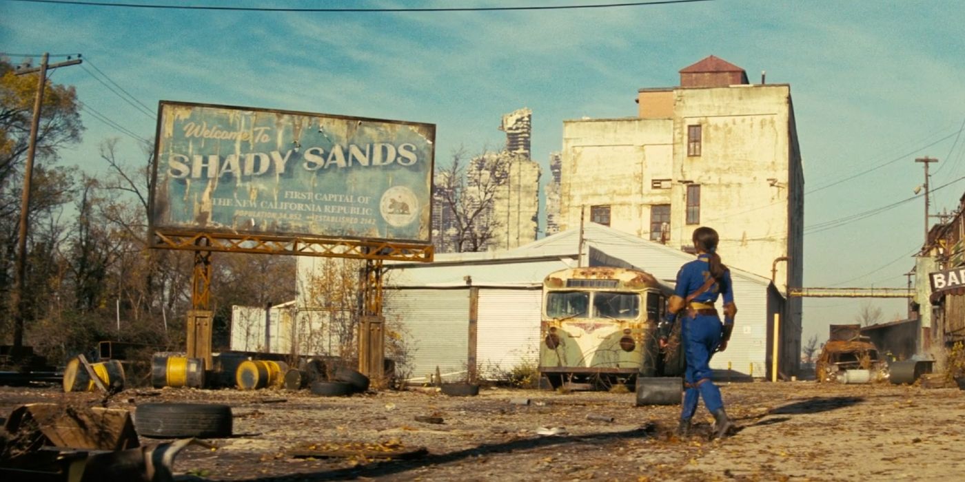 Ella Purnell como Lucy caminhando em direção a uma placa de Shady Sands na 1ª temporada de Fallout