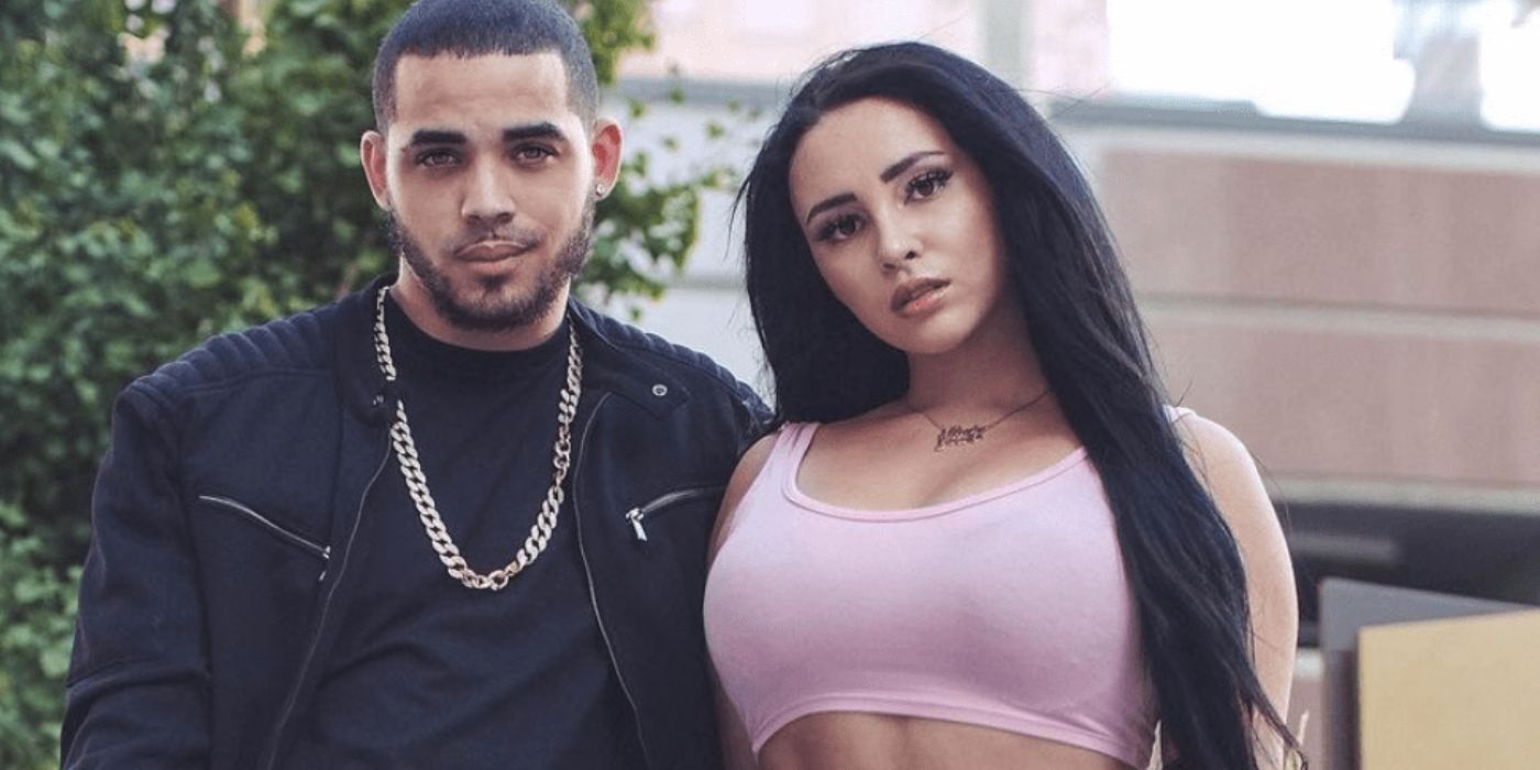 Sophie Sierra In 90 Day Fiance wearing pink crop top with black hair standing next to Rob Warne in black outfit