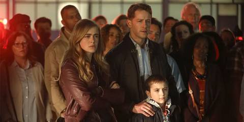 Michaela, Ben, and Cal looking concerned and standing in front of the other Flight 828 passengers
