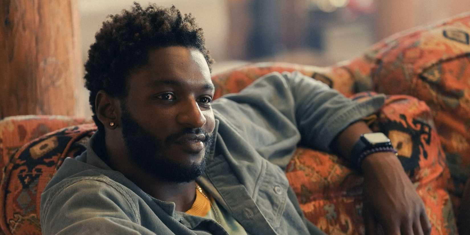 Tyson (Jay Will) sitting on a couch in Tulsa King
