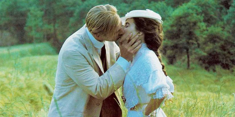 Lucy and George kissing in a field in A Room with a View.