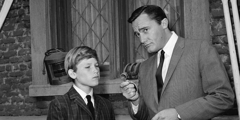 Napoleon and Christopher in front of a window in The Man From UNCLE.