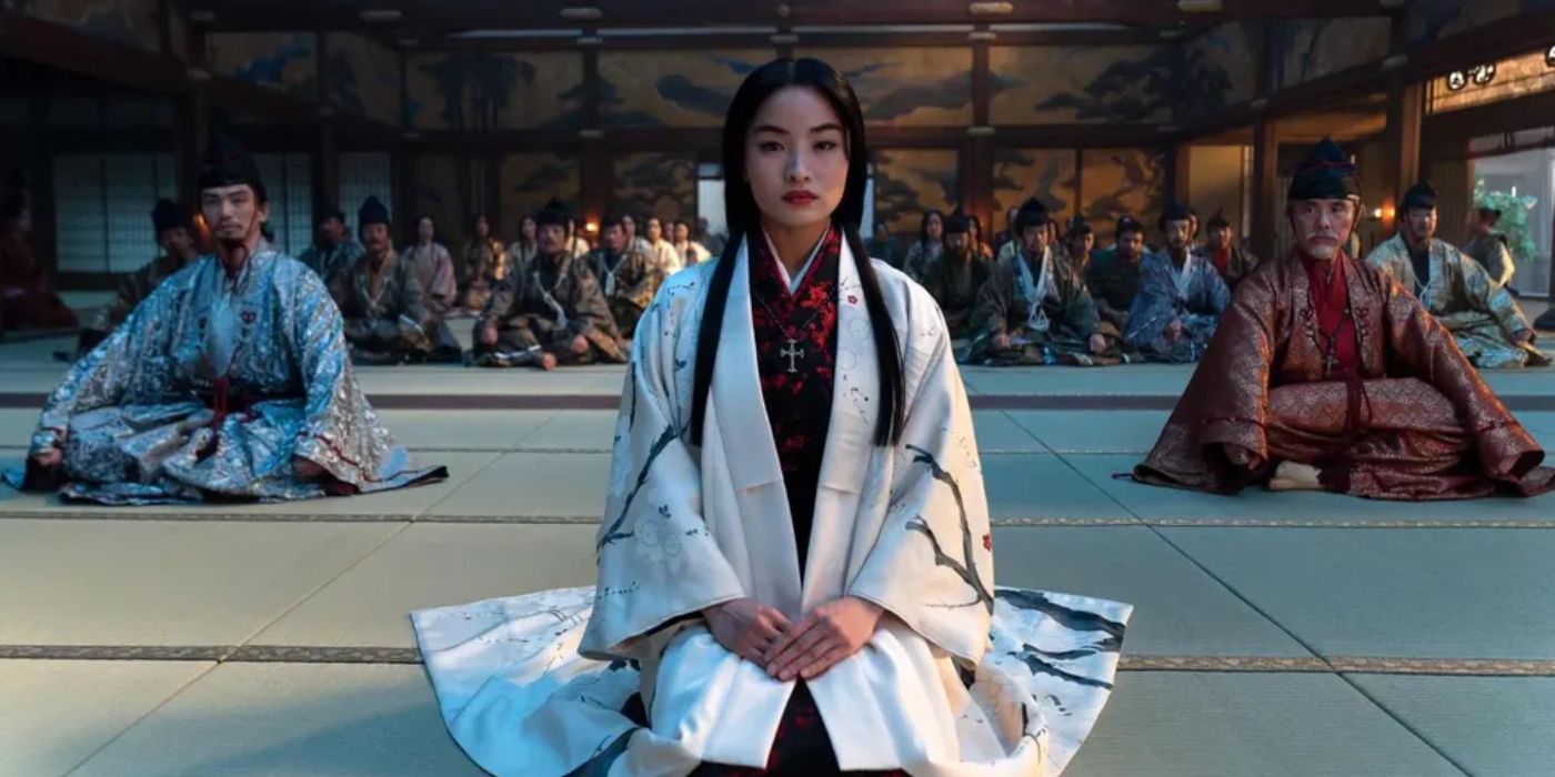 Mariko sat on the floor of a temple surrounded by other people in Shogun