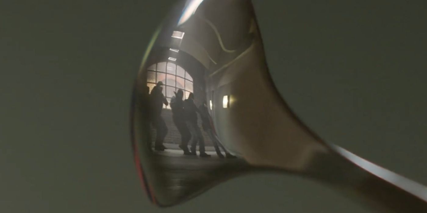 A group of soldiers entering a building, with Aidan and Elly watching in the reflection of a spoon in Argylle