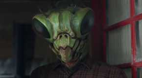 The Mantid standing in a doorway in Resident Alien