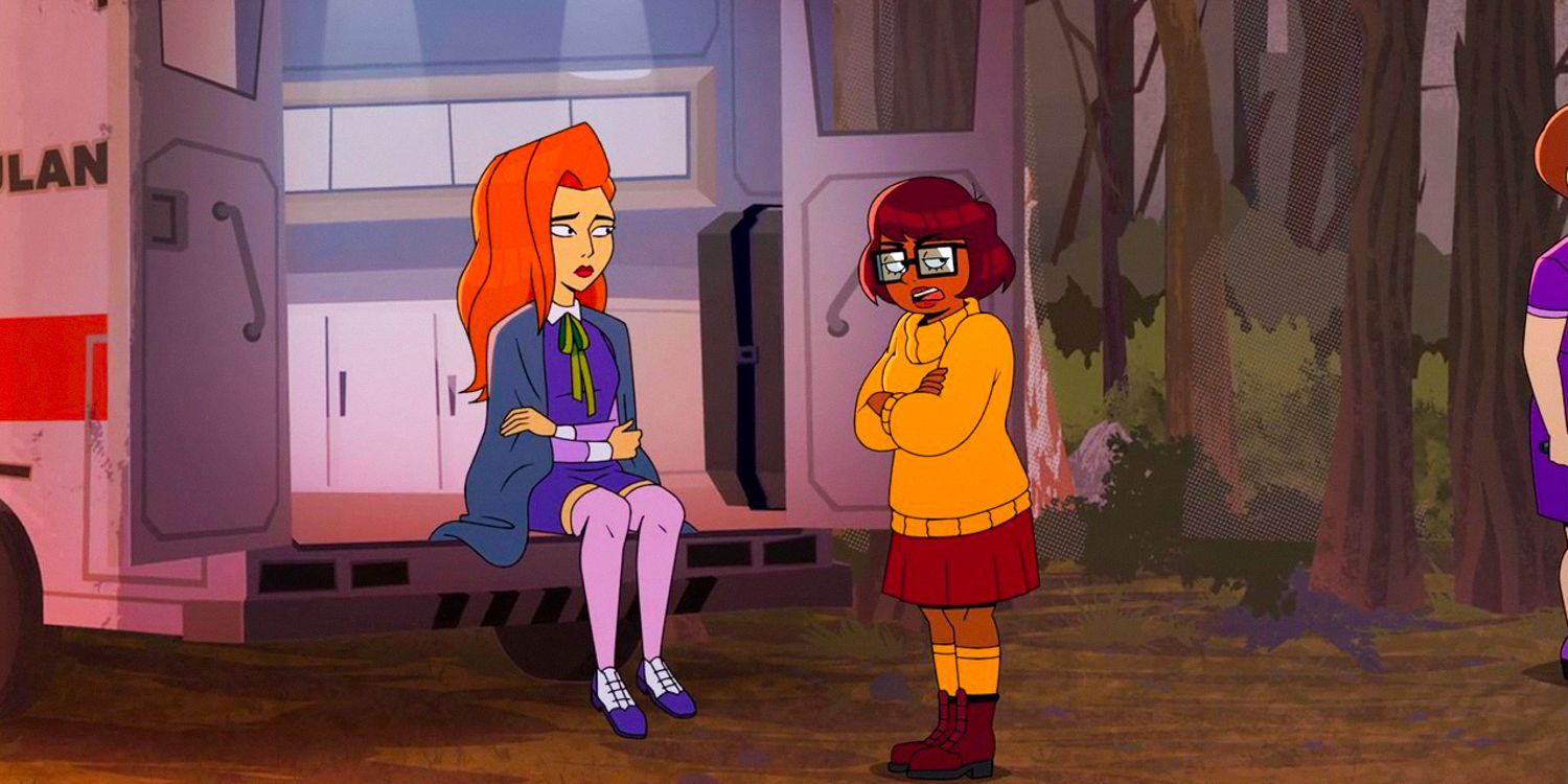 Daphne sitting in an ambulance, covered with a blanket, and Velma looking worrie in Velma season 2 ep 1