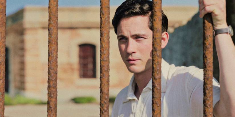 Addy (Logan Lerman) pensativo através de algumas grades no Brasil em We Were the Lucky Ones, temporada 1, episódio 5
