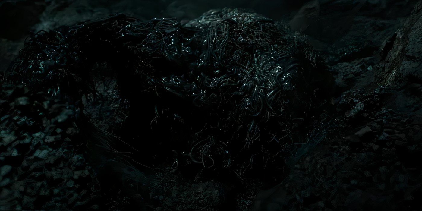 A strange black monster in The Rings of Power season 2 trailer crawling upwards from rocks.