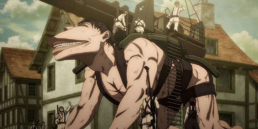 Attack on Titan's Cart Titan kneeling in the middle of a city with a turret strapped to its back and people crawling over it.