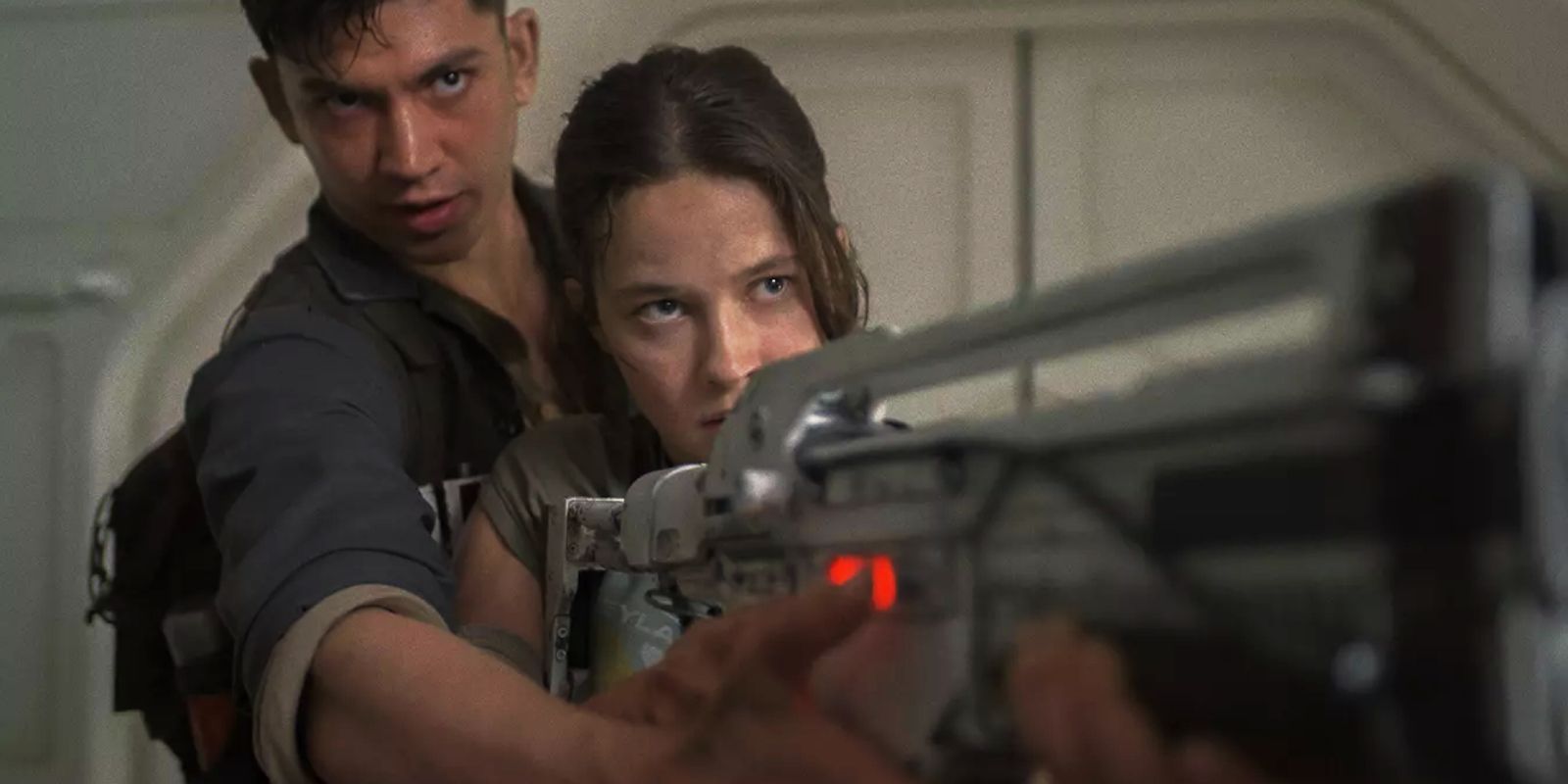 Cailee Spaeny and Archie Renaux aiming a gun in Alien: Romulus