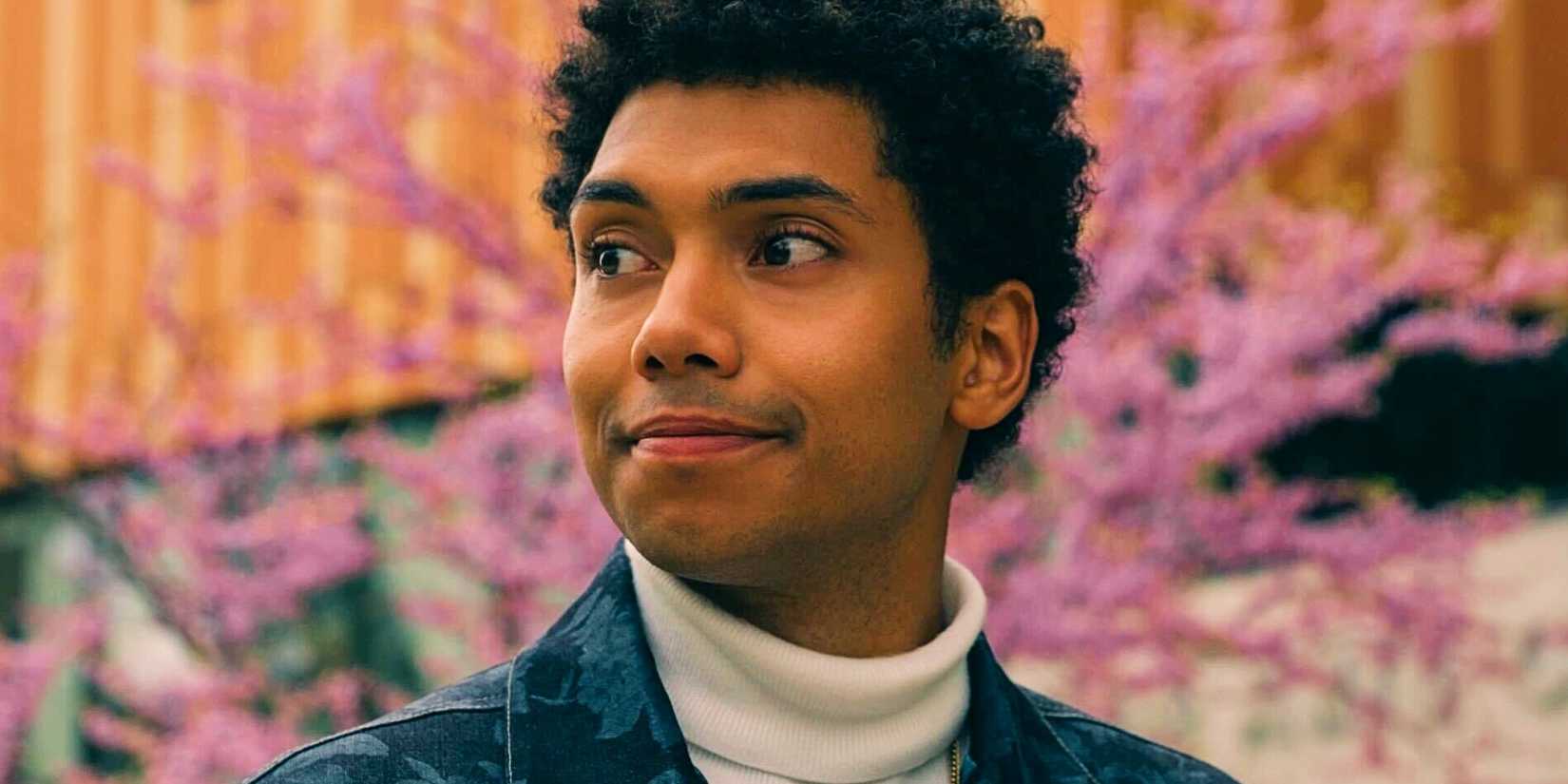 Chance Perdomo as Andre smiling in Gen V season 1 with a cherry blossom tree behind him