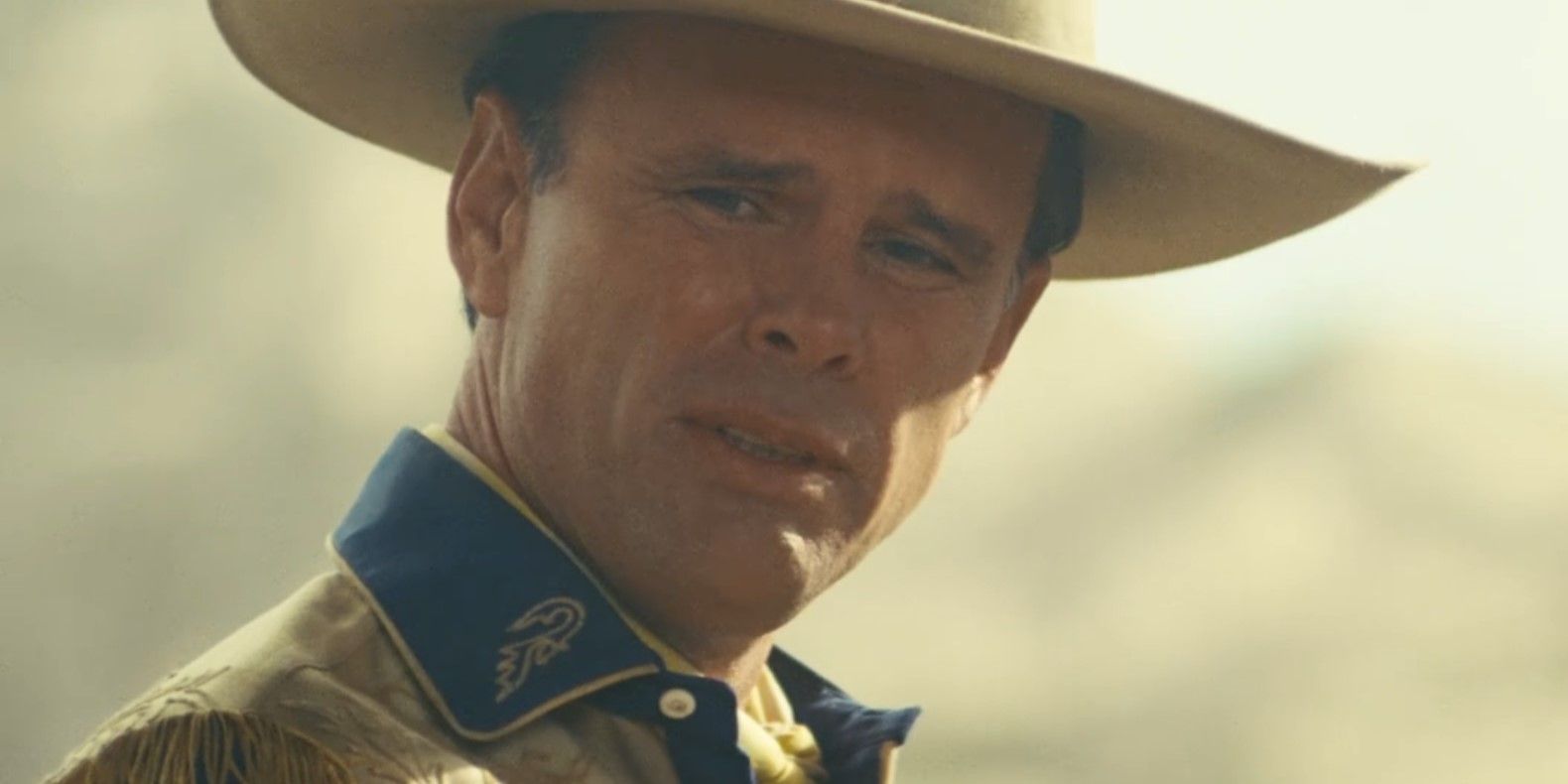 Cooper Howard (Walton Goggins) looks to the side with a confused look on his face while wearing a cowboy hat in Fallout