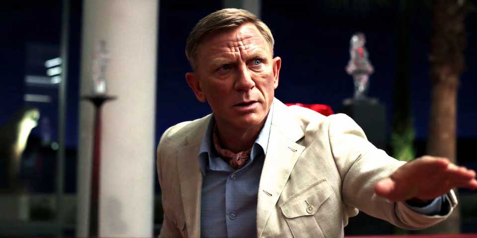Daniel Craig as Benoit Blanc trying to calm everyone down in Glass Onion A Knives Out Mystery.