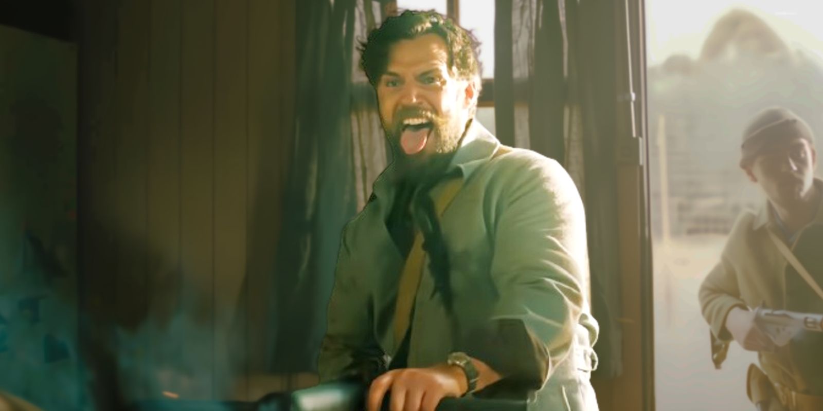 Henry Cavill shooting a gun and sticking his tongue out as Gus in The Ministry of Ungentlemanly Warfare.