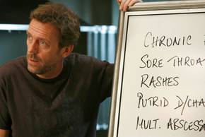 House (Hugh Laurie) looking dismissive at the white board in House
