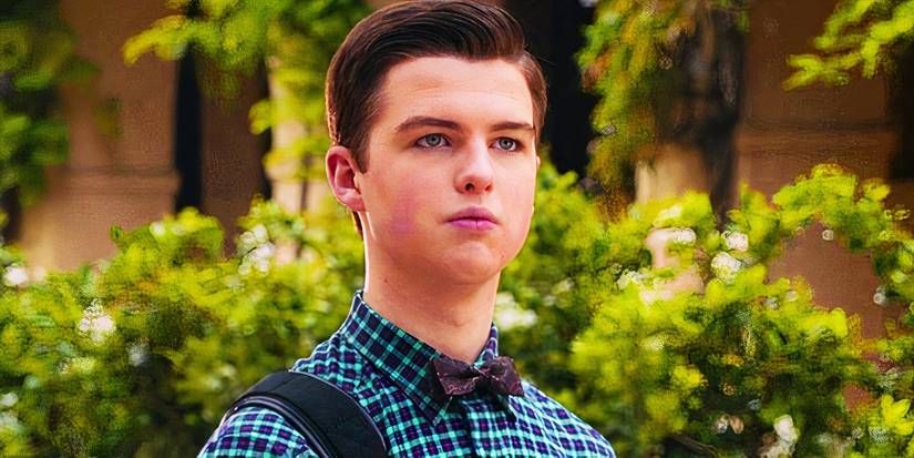 Iain Armitage as Sheldon standing outside with a building covered in greenery behind him in the Young Sheldon finale