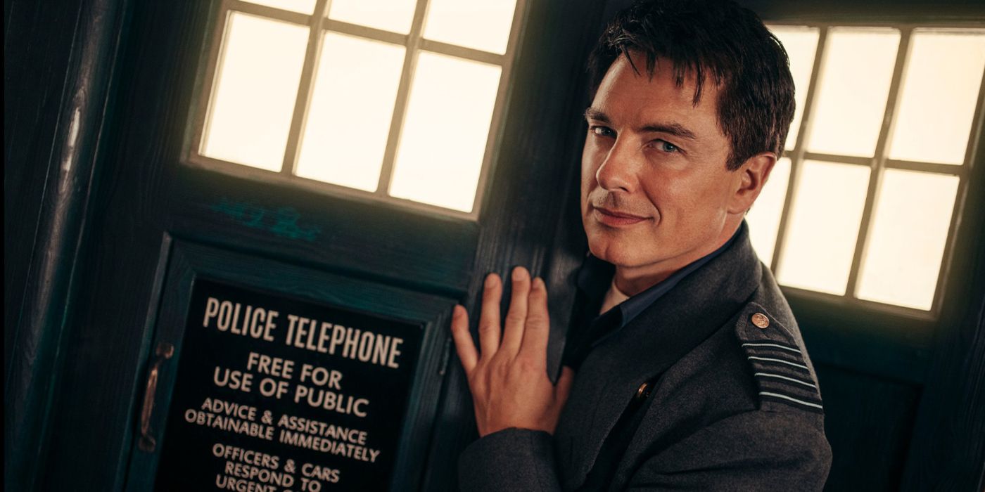 John Barrowman as Captain Jack Harkness smiling as he leans out of the TARDIS