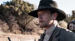 Jack O'Connell in Godless in a cowboy outfit with a western, dry desert background
