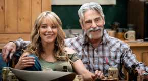 Laramie (Hassie Harrison) and Lloyd (Forrie J. Smith) laughing on a couch together in Yellowstone.
