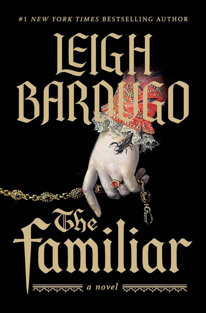 Leigh Bardugo The Familiar Book Cover Showing a Woman's hand holding a gold chain with Scorpion on her hand