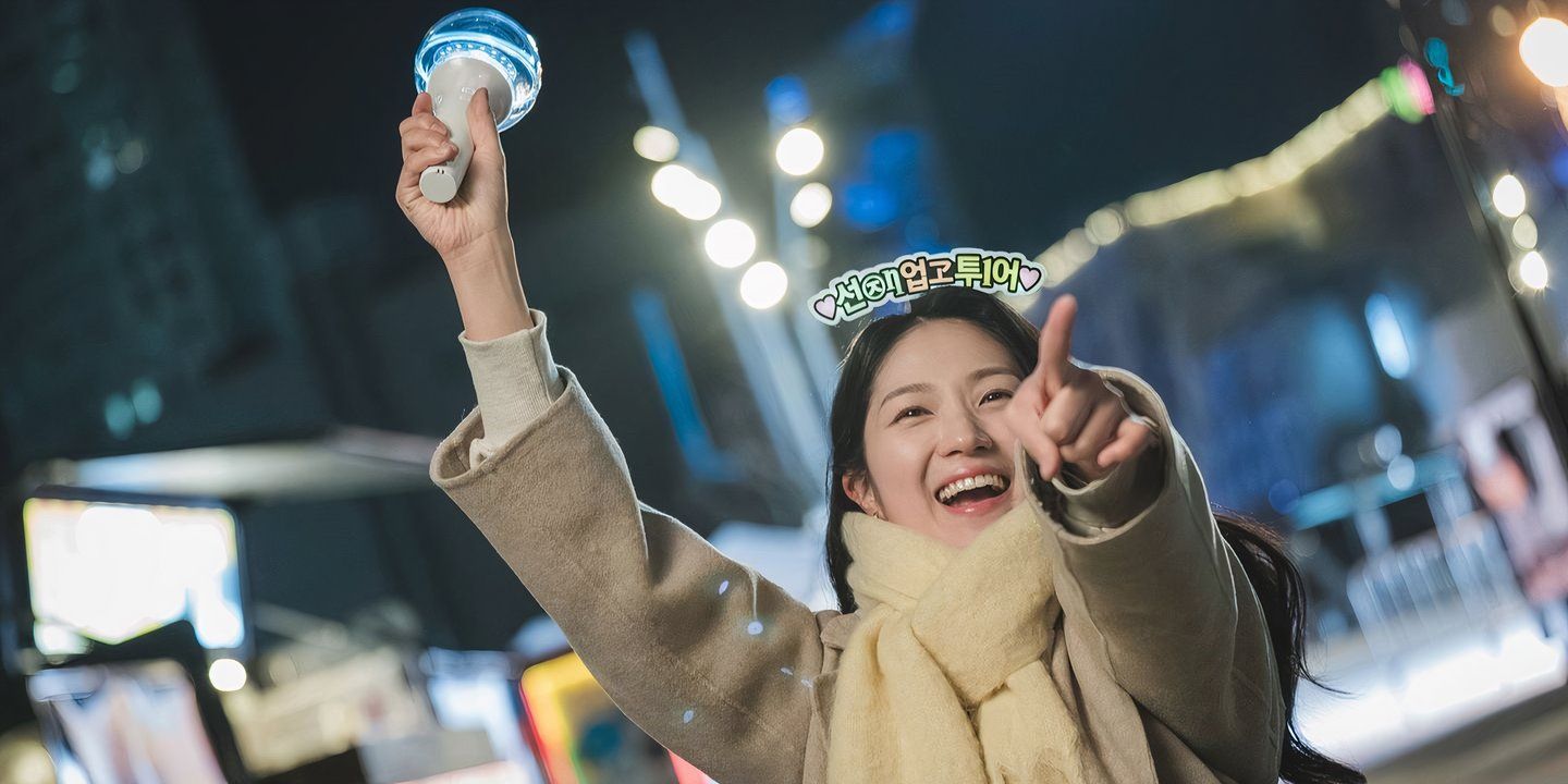 Lovely Runner's Im Sol smiles while holding a lightstick